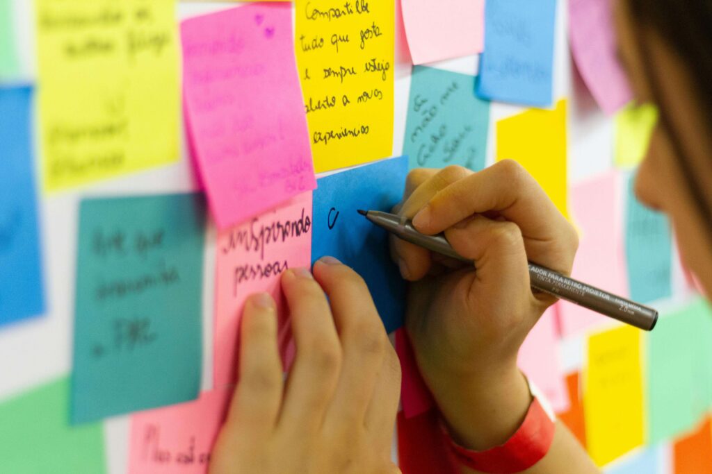 Girl writing self-improvement quotes and sticking them to a wall