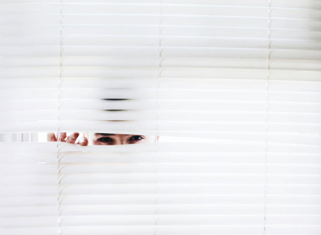 Person peeking through blinds