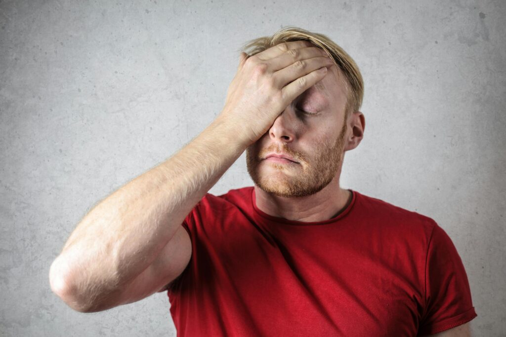 Man wearing a red t-shirt is sad and disappointed 